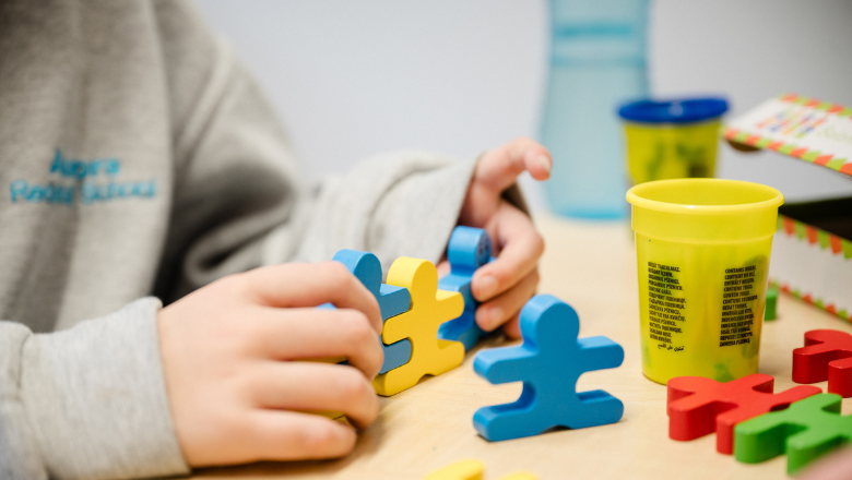 child playing with foam-shaped jigsaw pieces and placing them together